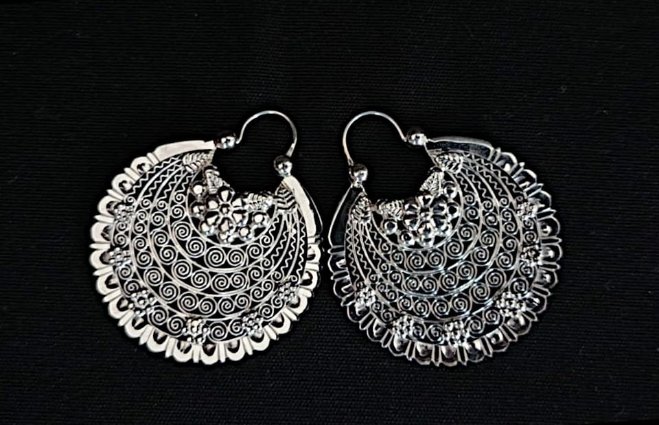 Large round silver filigree arracada earrings on black fabric